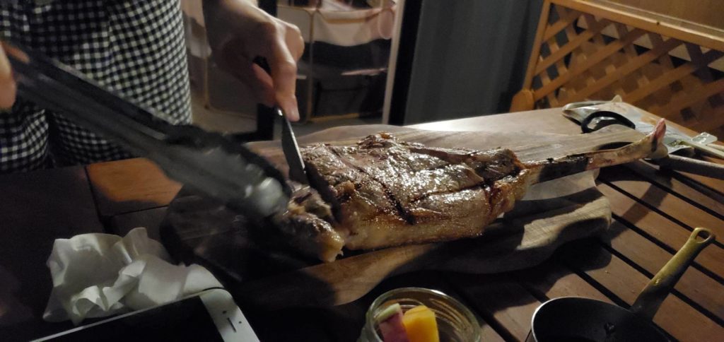 夕食はバーベキュー方式。肉を切ってる写真。
